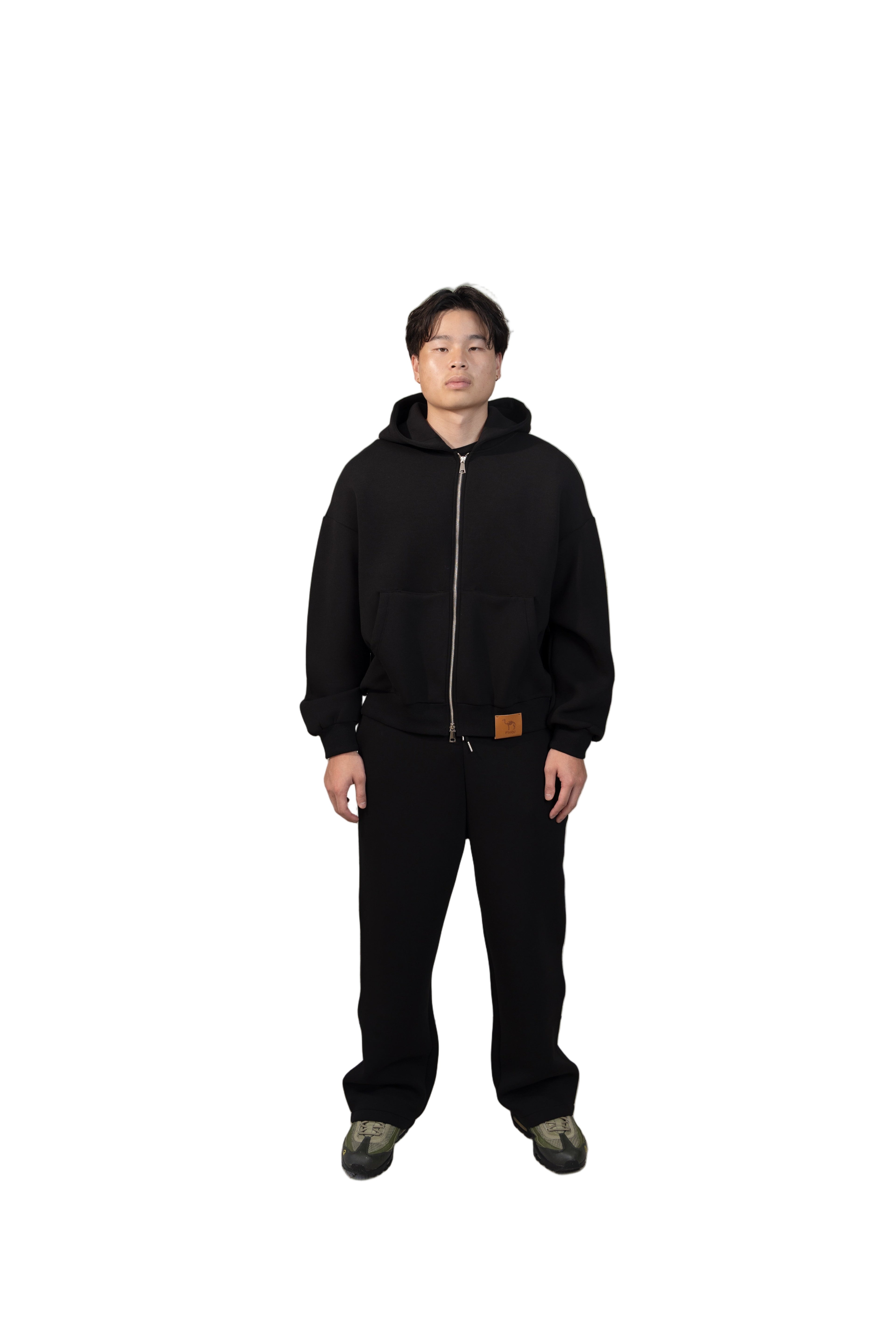 Person wearing a black outfit standing in a modern living room.