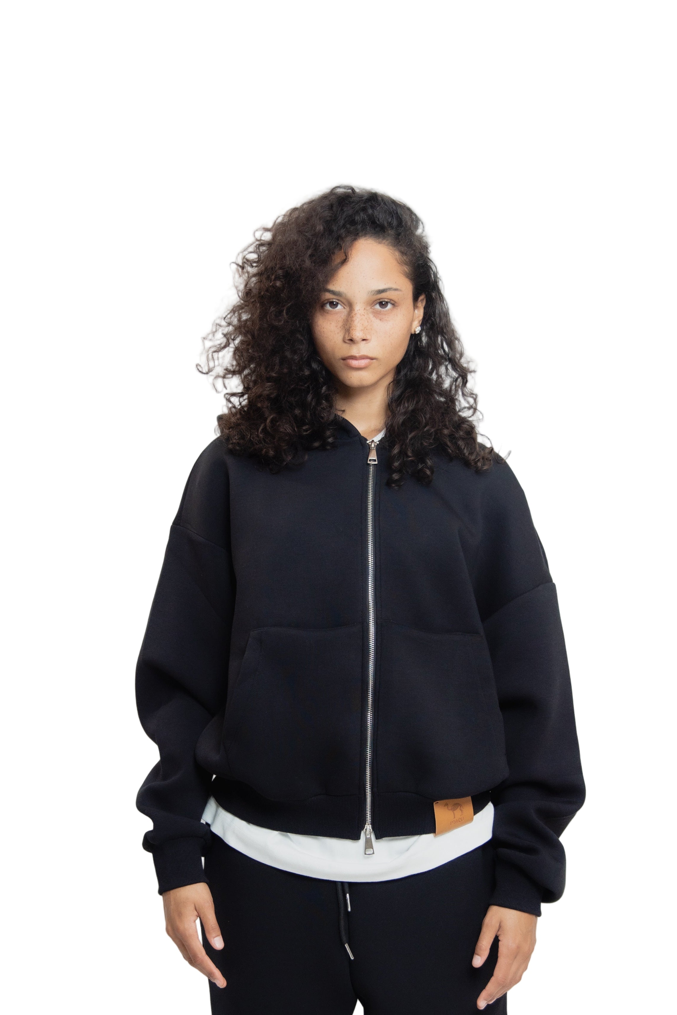 Person wearing a black tracksuit with white shirt on a white background