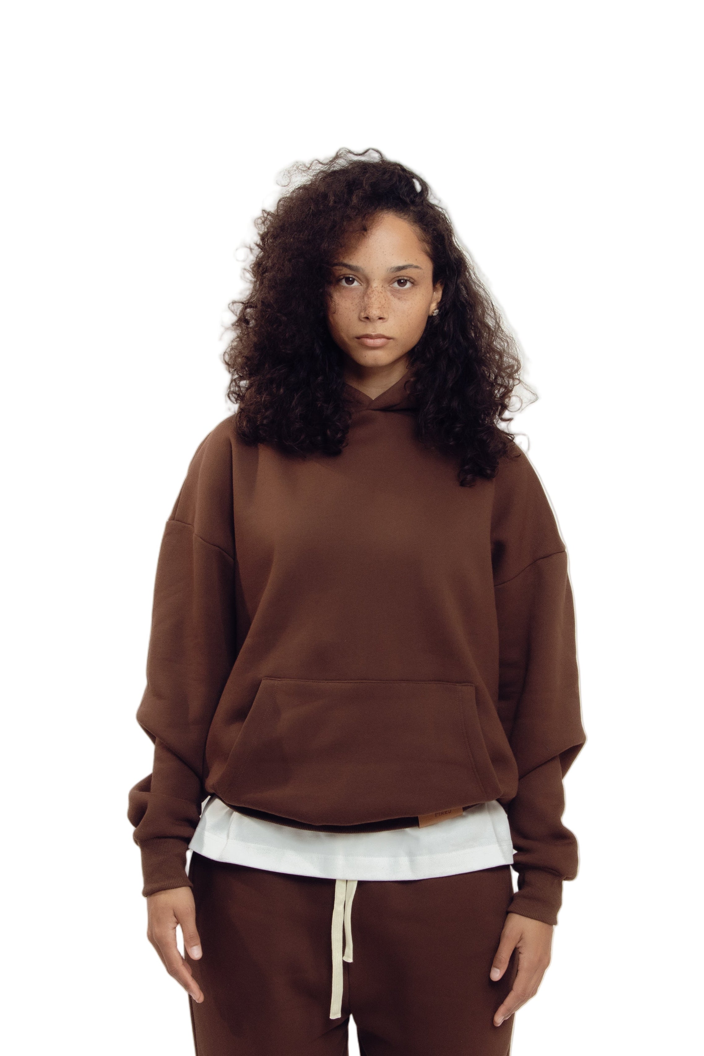 Person wearing a brown sweatshirt and pants on a white background